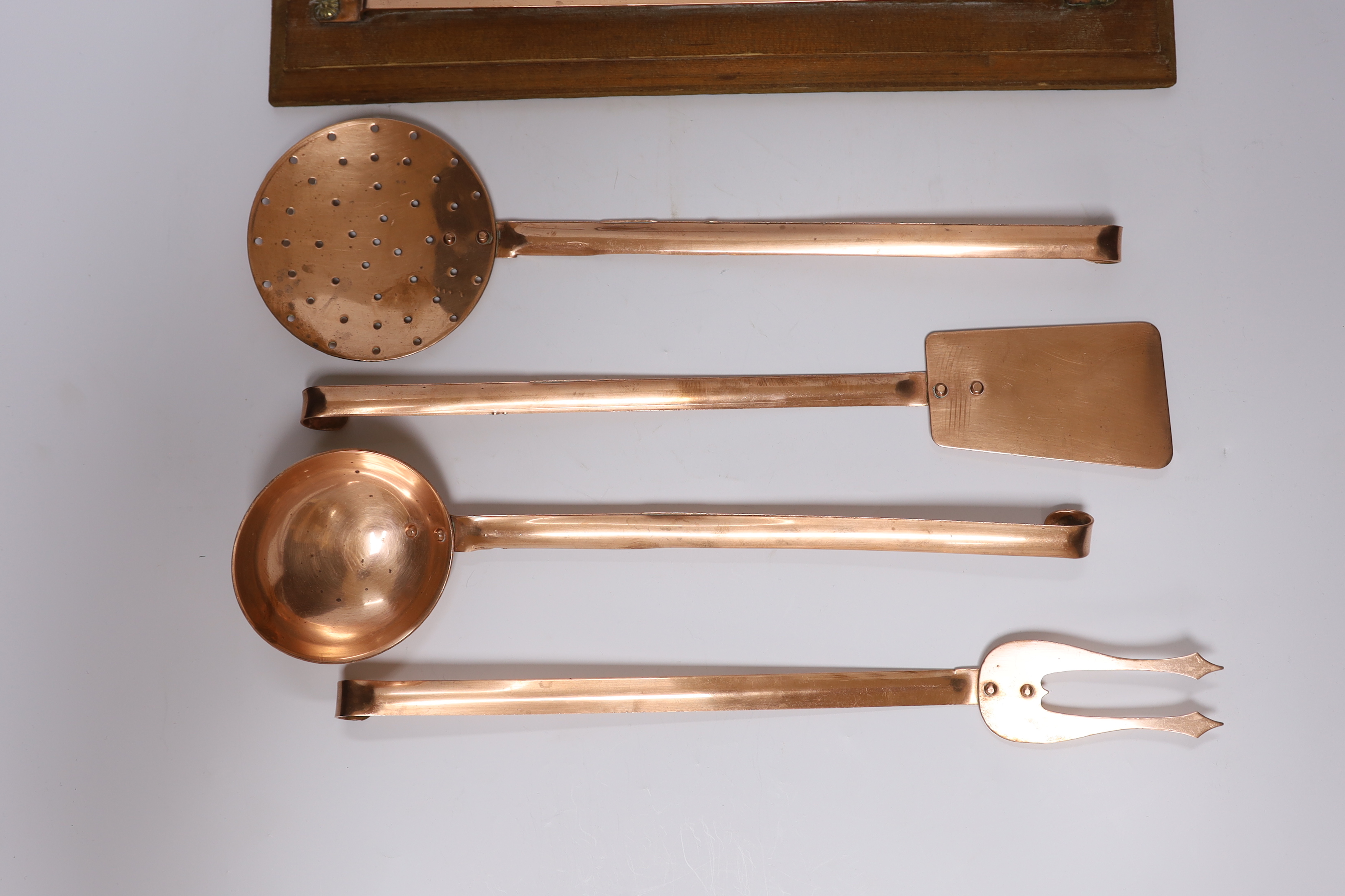 A set of five French copper utensils with hanging rack